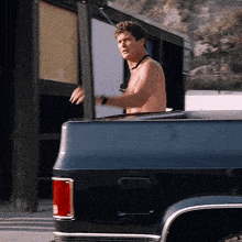 a shirtless man is getting out of a truck