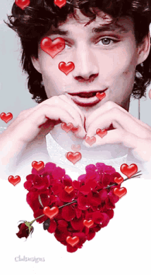 a man is making a heart shape with his hands and hearts are coming out of his eyes
