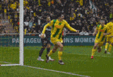 a soccer player wearing a yellow and green jersey with the number 66 on it is running on the field