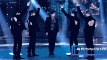 a group of men standing on a stage with jr performance written in the corner