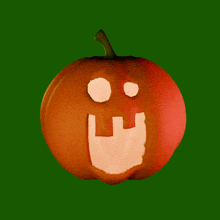 a pumpkin with a smiley face carved into it on a green background