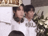 two men are standing next to each other in front of a sign that says vibe