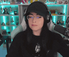a woman wearing glasses and headphones is sitting in a chair in front of a microphone .