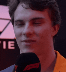 a close up of a man 's face with his eyes closed and a microphone in front of him