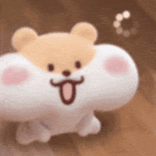 a stuffed animal with a teddy bear head and a tongue sticking out is sitting on the floor .