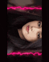 a woman 's face is split in half by a neon glowing border