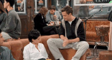 a group of people sitting on a couch in front of a sign that says ' very '