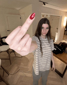 a woman with red nail polish giving the middle finger