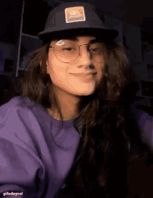 a girl wearing glasses and a hat with the word nike on it
