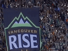 a vancouver rise banner is being held up in front of a crowd