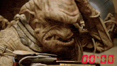 a close up of a monster with a clock that says 00:00 in red