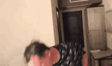 a person is standing in a room with a bag on the floor and a couch .