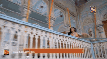 an ad for sony tv shows a woman dancing on a balcony