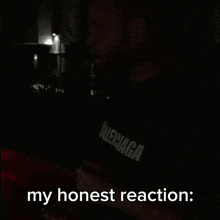 a man smoking a cigarette with the words my honest reaction written below him