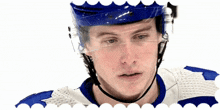 a hockey player wearing a blue helmet and a white and blue jersey