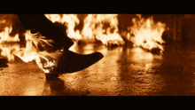 a person is standing in front of a wall of fire