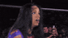 a woman in a purple and red outfit is pointing her finger