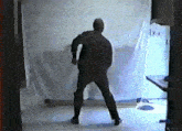 a man in a black hoodie is standing in front of a white curtain that says ' i ' on it