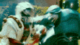 a blurry picture of a man in a white suit fighting another man in a blue suit