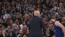 a man in a suit talks to a basketball player in a barcelona jersey