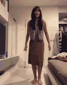 a woman in a brown skirt is standing in front of a closet