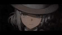 a close up of a girl wearing a hat and looking at the camera .