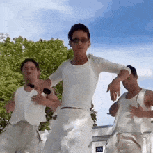 a man in a white shirt is dancing with two other men