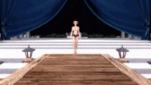a woman in a bikini is standing on a dock in front of a blue curtain
