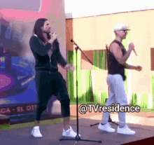 two men singing and dancing on a stage with the words @tvresidence written on the bottom