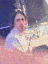 a blurry picture of a man smoking a cigarette with a crowd in the background