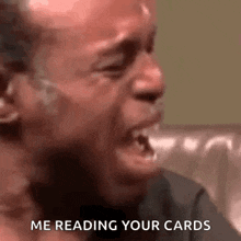 a man is crying while sitting on a couch with his mouth open .