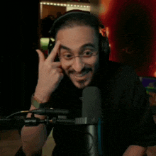 a man wearing headphones is sitting in front of a microphone
