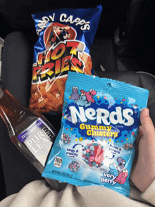 a person holding a bag of nerds gummy clusters