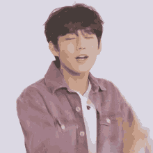 a young man wearing a purple jacket and a white shirt is making a funny face .