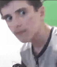 a close up of a young man 's face in front of a green screen .