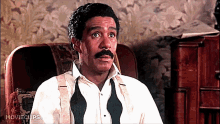 a man in a tuxedo sits in a chair with movieclips written on the bottom of the screen