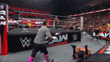 a wrestling match is going on in a stadium with a banner that says raw on it