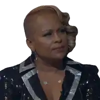 a woman wearing a black and silver sequined jacket and silver earrings