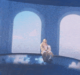a man in a white shirt is sitting in a blue room with arches