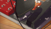 a guitar pedal board with a shoe on it