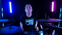 a man blowing a kiss while playing drums with a shirt that has the letter a on it