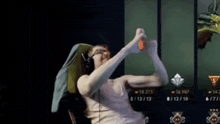 a woman is sitting in a chair wearing headphones and holding a controller .