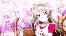 a girl is standing in front of a cherry blossom tree with a flower in her hair .