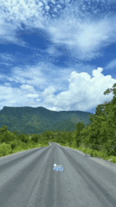 a road with mountains in the background and a sign that says ' jeep ' on it