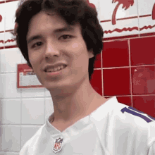a man wearing a white nfl jersey is smiling