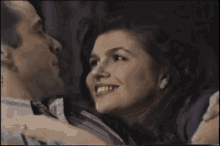 a man is kissing a woman on the cheek in a dark room