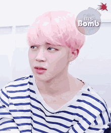 a boy with pink hair is wearing a blue and white striped shirt with a sticker that says bts bomb