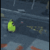 a pink cartoon character with a green hat is walking down the street