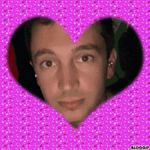 a man 's face is framed in a heart shaped frame on a pink background
