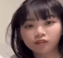 a close up of a young girl 's face with a serious look on her face .